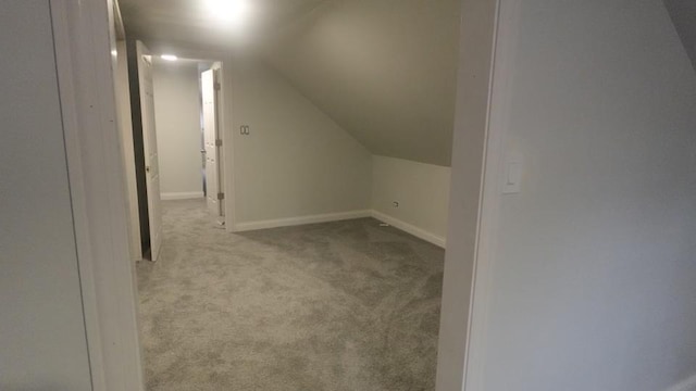 additional living space with vaulted ceiling, baseboards, and carpet floors