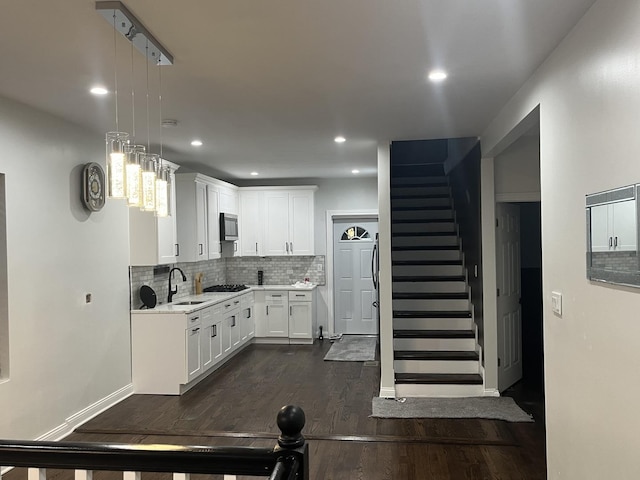 kitchen with tasteful backsplash, light countertops, dark wood-style floors, stainless steel appliances, and a sink