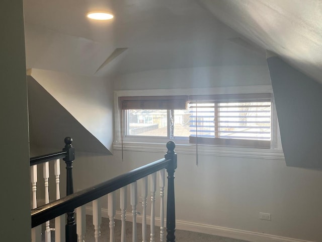 stairs featuring baseboards and vaulted ceiling