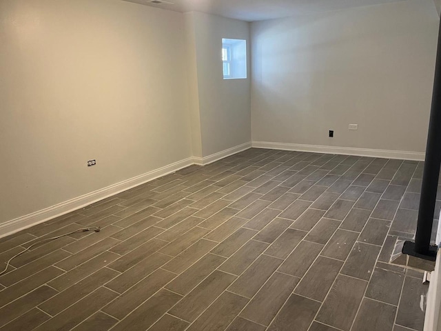 unfurnished room with baseboards and wood finish floors