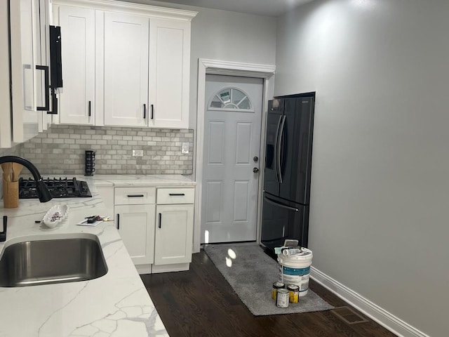 kitchen with a sink, white cabinets, black appliances, and dark wood-style flooring