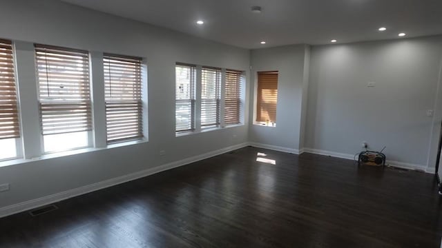 spare room featuring recessed lighting, visible vents, baseboards, and dark wood-style flooring