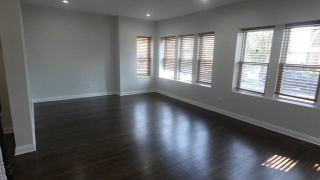 spare room featuring recessed lighting, baseboards, and dark wood finished floors