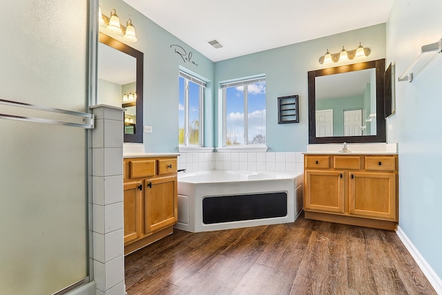 330 Alexis St, Plano, IL 60545 - bathroom with wood finished floors, vanity, a garden tub, and visible vents