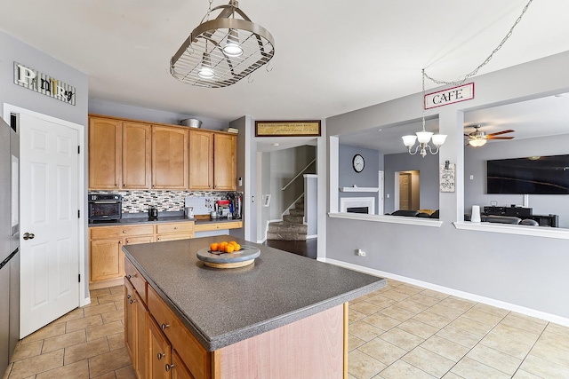330 Alexis St, Plano, IL 60545 - kitchen with baseboards, light tile patterned floors, a kitchen island, dark countertops, and decorative backsplash