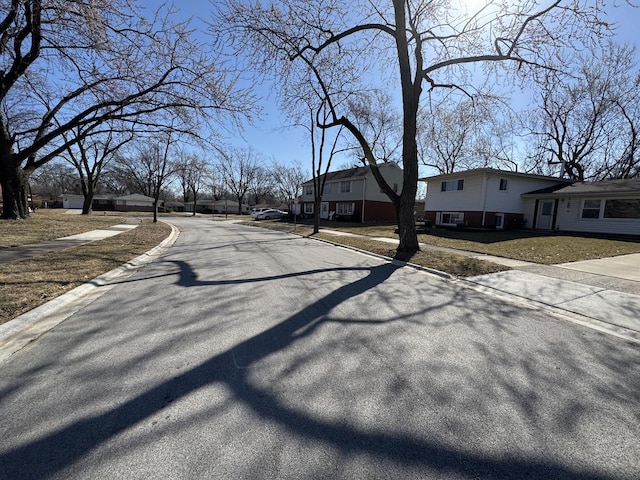 view of road with a residential view, curbs, and sidewalks