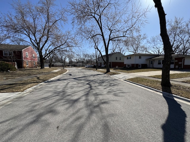 view of road with sidewalks, a residential view, and curbs