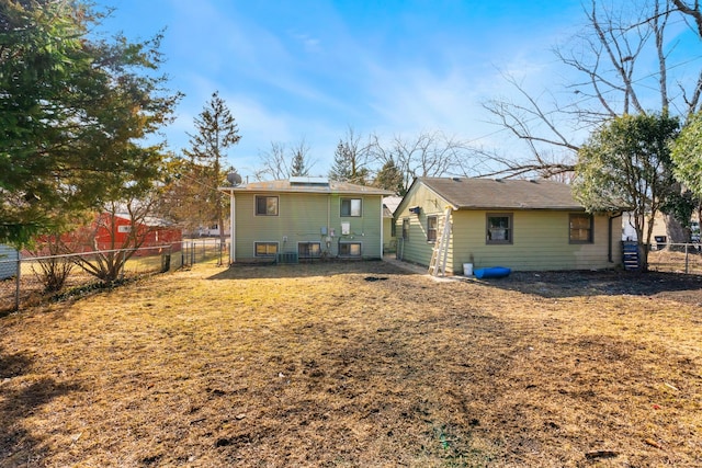 rear view of house with cooling unit and fence