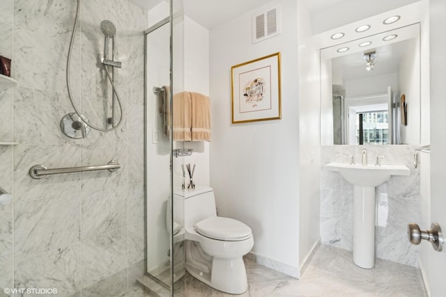 bathroom featuring baseboards, visible vents, a tile shower, toilet, and marble finish floor