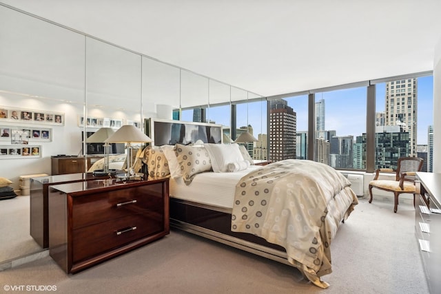 carpeted bedroom with a city view and expansive windows