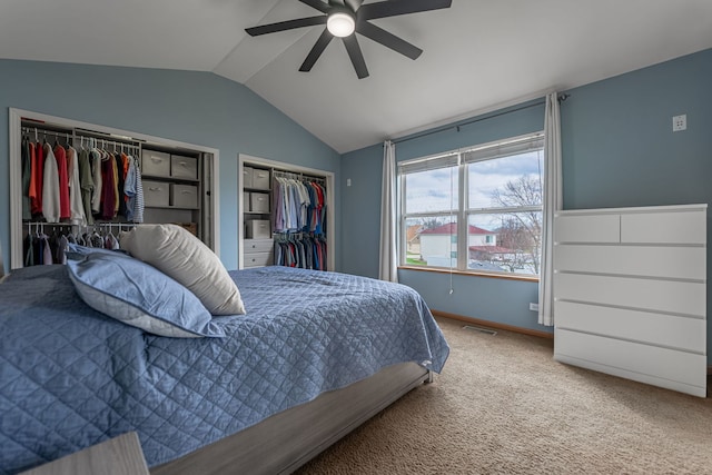 bedroom featuring carpet flooring, multiple closets, visible vents, ceiling fan, and lofted ceiling