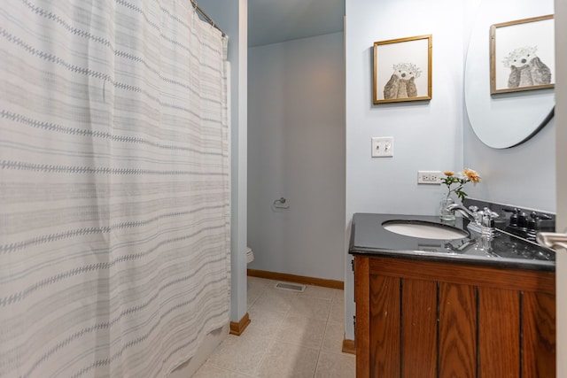 bathroom with toilet, vanity, tile patterned flooring, baseboards, and visible vents