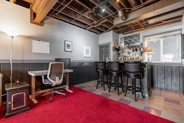 bar with a wainscoted wall, a dry bar, and tile patterned floors