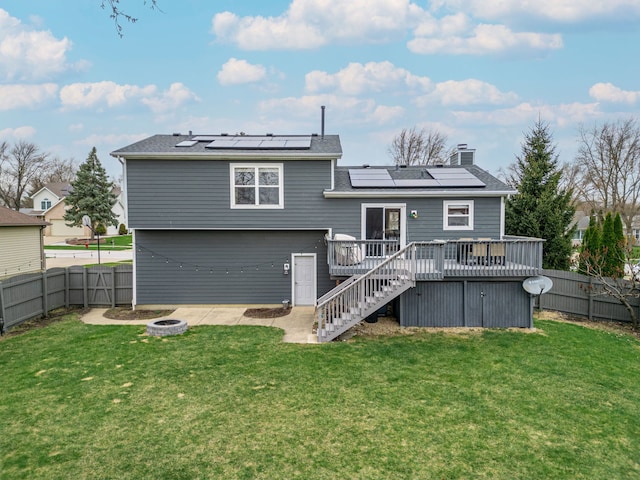 back of house featuring a fire pit, stairway, a chimney, a deck, and a fenced backyard