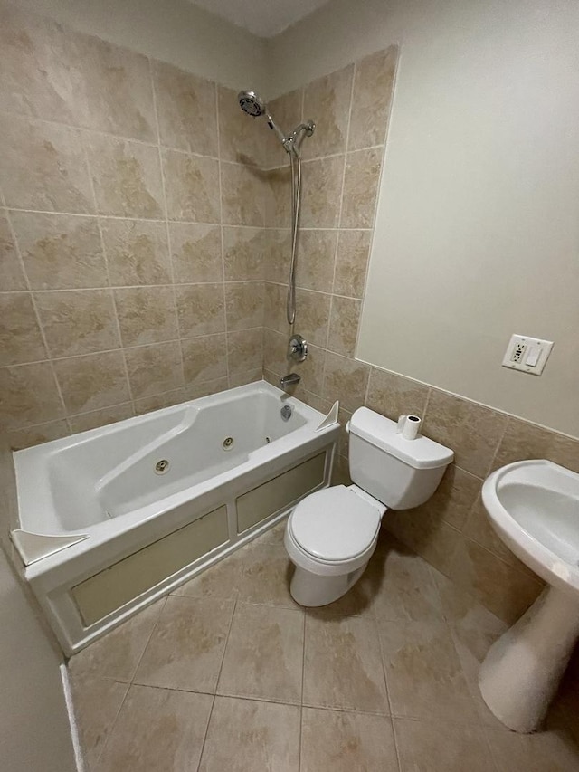 full bathroom featuring tile walls, toilet, a combined bath / shower with jetted tub, and tile patterned floors