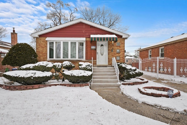 bungalow-style home featuring fence and brick siding