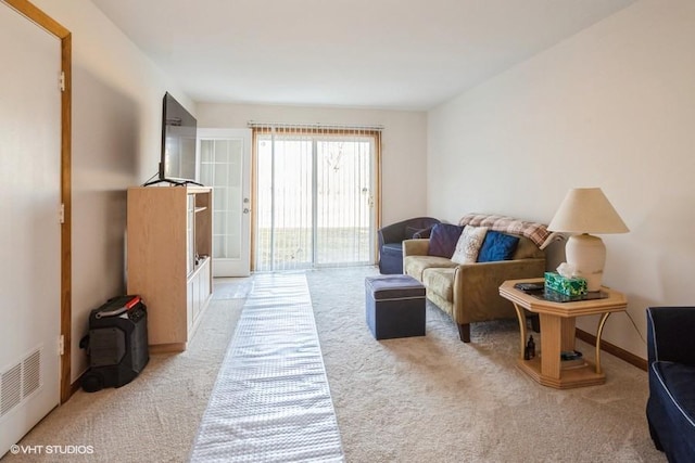 living area featuring baseboards and light colored carpet