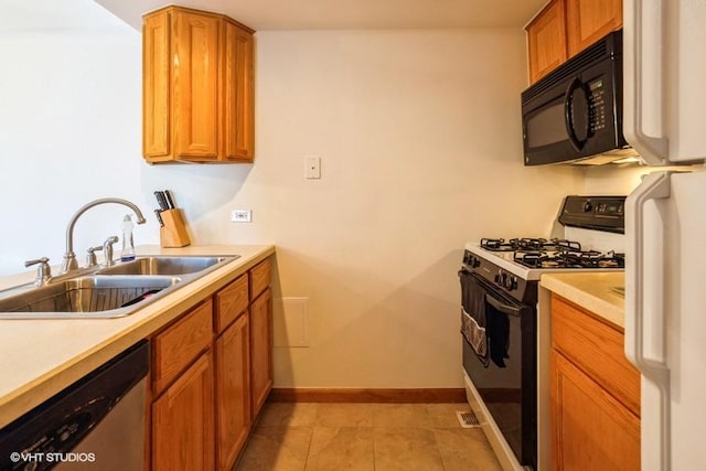 kitchen with black microwave, dishwasher, light countertops, gas range oven, and a sink