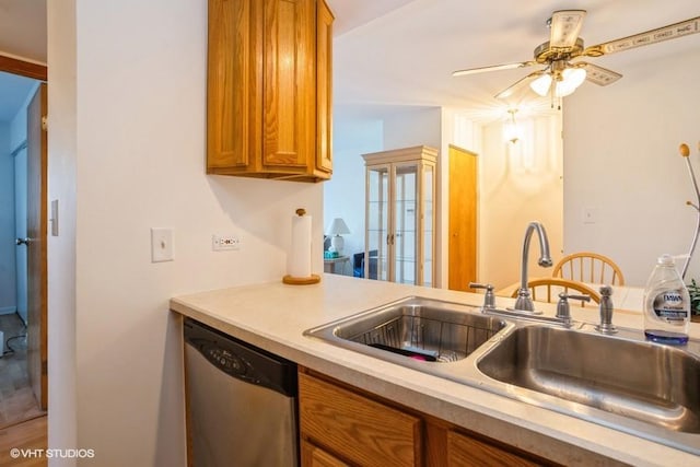 kitchen featuring a sink, brown cabinetry, light countertops, dishwasher, and ceiling fan