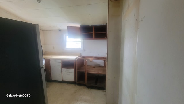 809 W Columbia St, Danville, IL 61832 - kitchen with freestanding refrigerator, open shelves, and unfinished concrete flooring