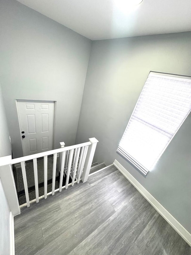 stairway with wood finished floors and baseboards