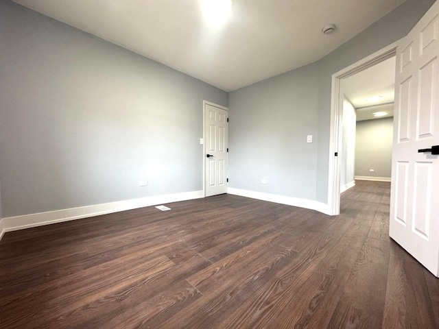 unfurnished room featuring dark wood finished floors and baseboards