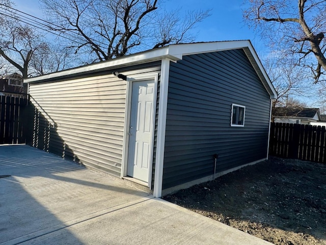 view of property exterior with an outdoor structure and fence