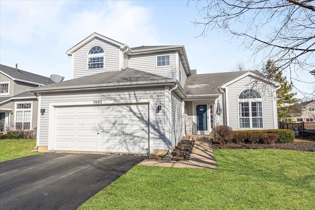 traditional home featuring driveway, a shingled roof, fence, a front yard, and an attached garage