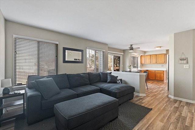 living area featuring light wood-style floors and baseboards