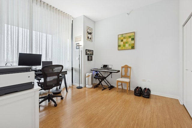 office with light wood-type flooring and baseboards