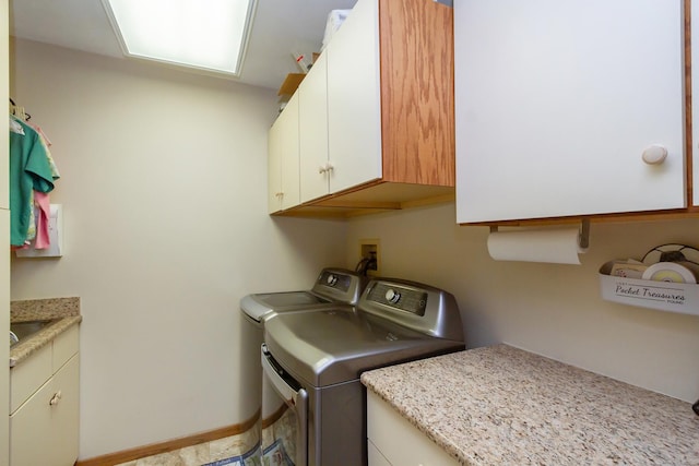 washroom with washer and dryer, baseboards, and cabinet space