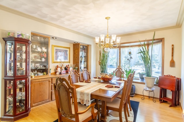 dining space with light wood-type flooring, an inviting chandelier, and crown molding