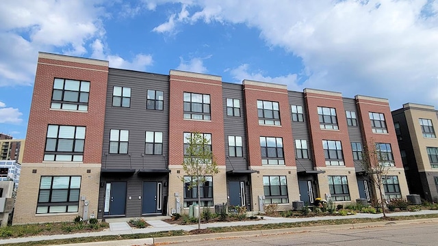 view of front of property with central AC unit and brick siding