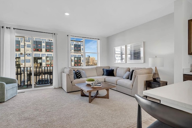 living area with recessed lighting and light carpet