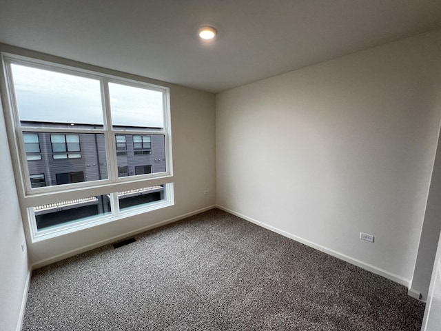 empty room with visible vents, baseboards, and carpet floors