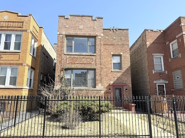 view of front of property featuring a fenced front yard and brick siding