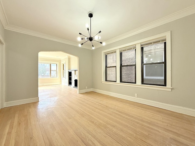 interior space featuring an inviting chandelier, light wood-style flooring, arched walkways, and ornamental molding