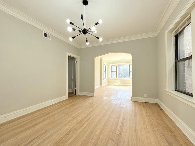 empty room featuring visible vents, baseboards, a chandelier, light wood-style flooring, and arched walkways