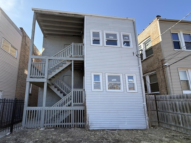 back of property featuring stairway and fence