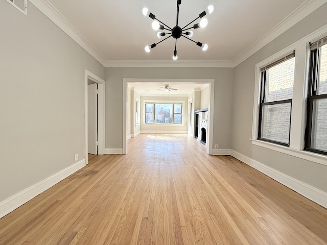 unfurnished living room featuring visible vents, a notable chandelier, light wood-style flooring, ornamental molding, and baseboards