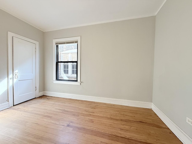 unfurnished room featuring light wood-type flooring, baseboards, and crown molding