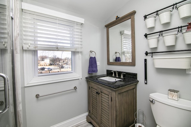 bathroom with baseboards, toilet, and vanity