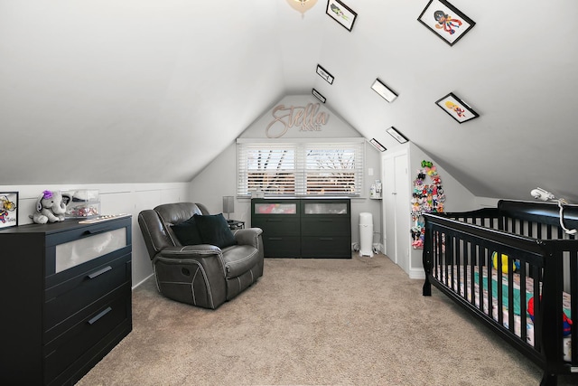 carpeted bedroom with a crib and vaulted ceiling