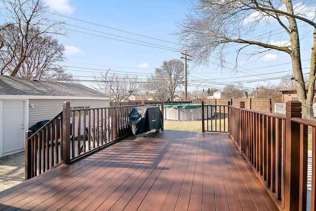 wooden deck with a fenced in pool, a grill, and a fenced backyard