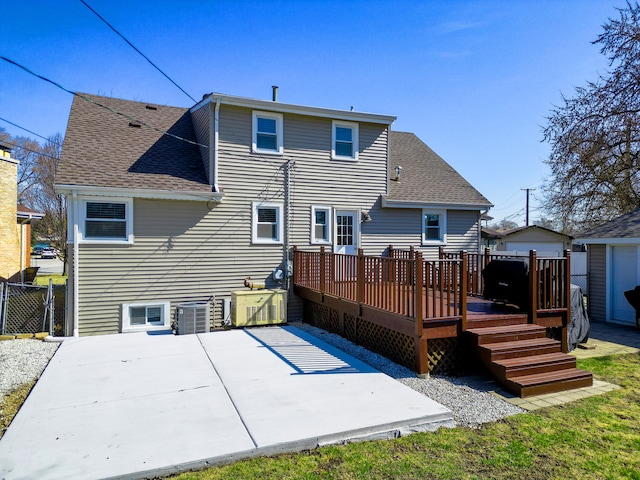 back of house with a patio, a wooden deck, fence, and a shingled roof