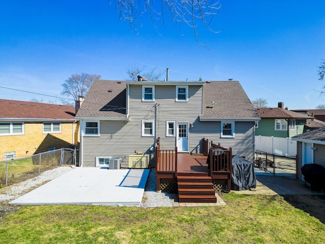 rear view of property with roof with shingles, a lawn, a fenced backyard, a patio area, and a gate