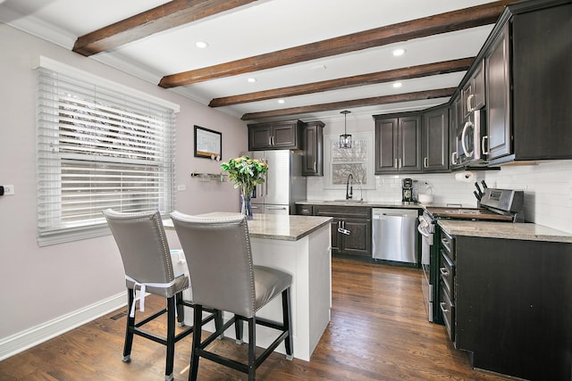 kitchen with a breakfast bar, dark wood-type flooring, appliances with stainless steel finishes, and a sink