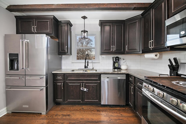 kitchen featuring dark wood-type flooring, light stone countertops, beamed ceiling, stainless steel appliances, and a sink