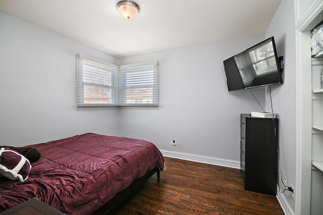 bedroom featuring wood finished floors and baseboards