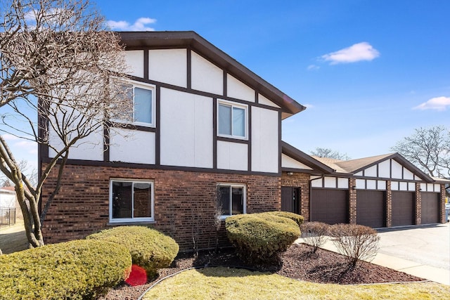 view of front of house featuring an attached garage, brick siding, and driveway